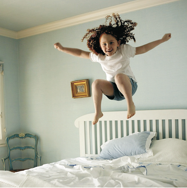 Nena saltant al llit
