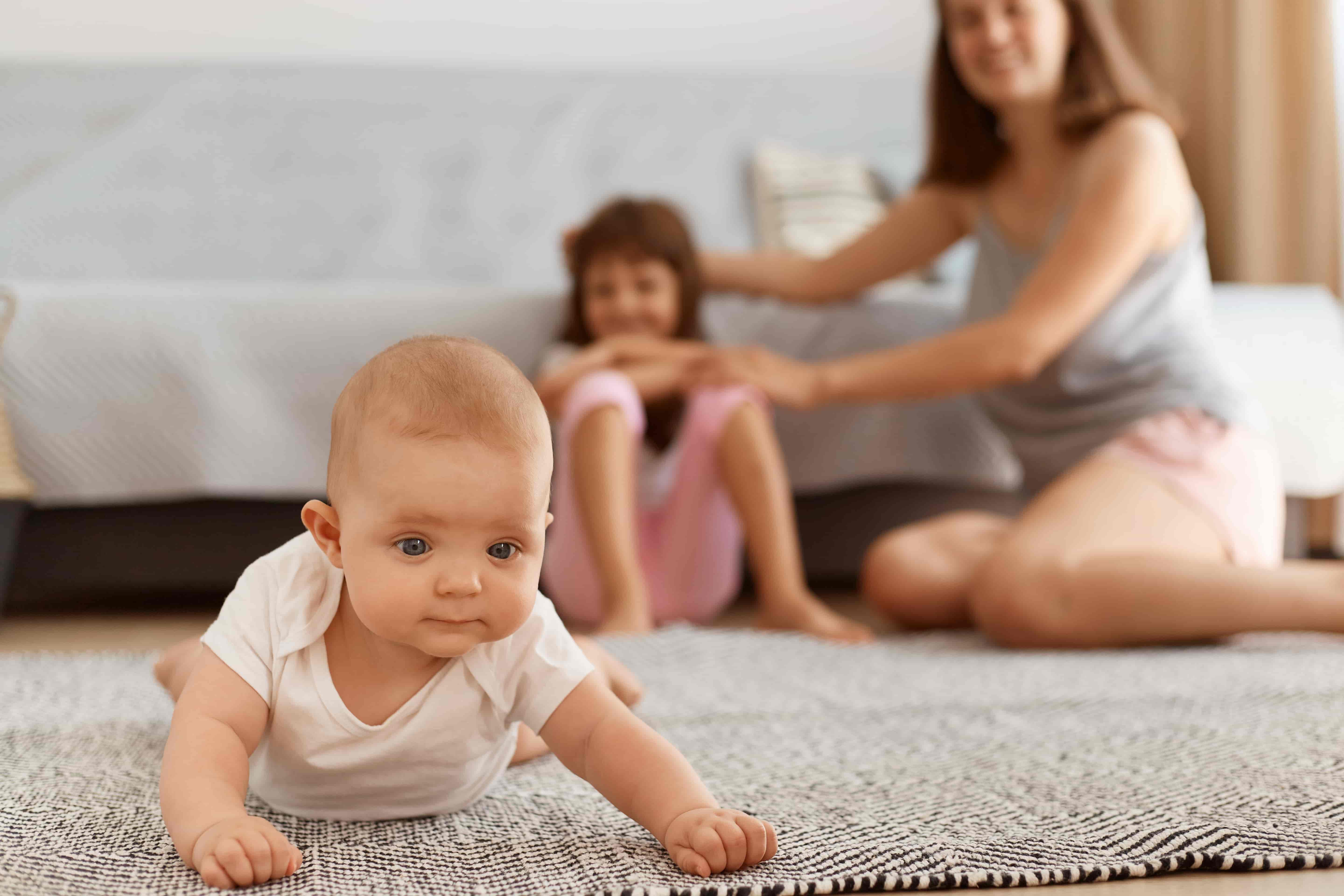 Bebé gateando en la alfombra de casa 