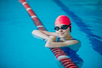 niña con gorro y gafas practicando natación