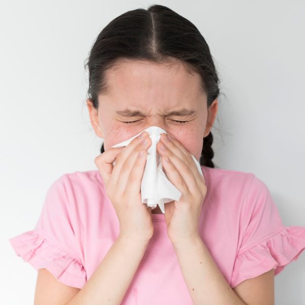 Niña con alergia sonándose la nariz