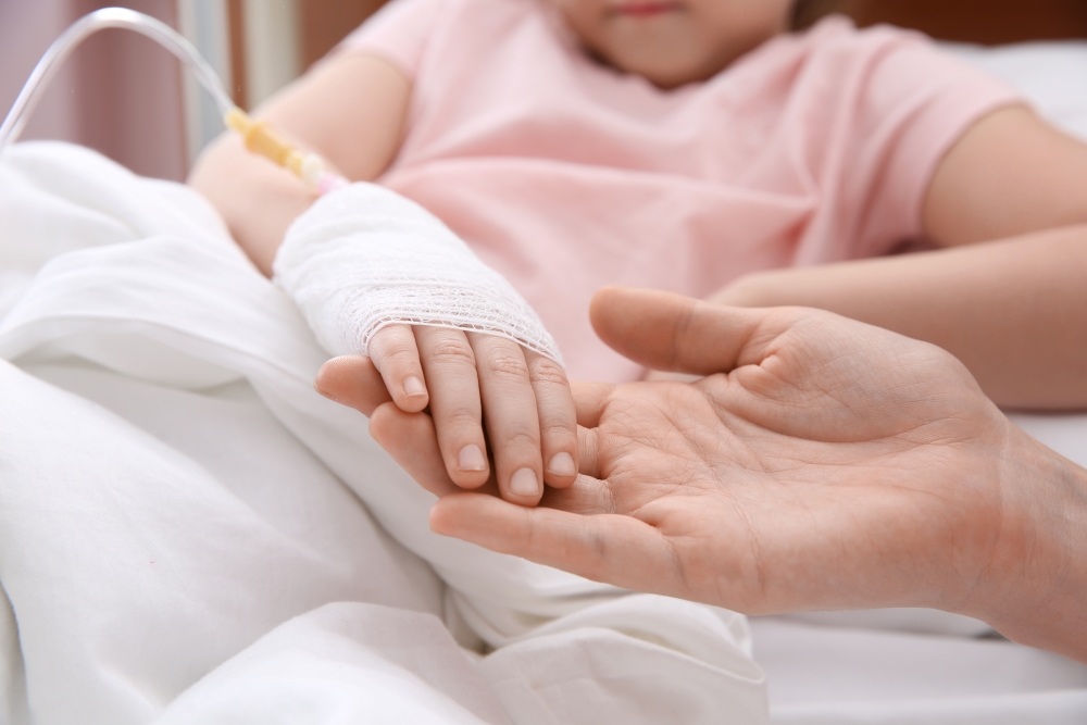 Niña con una vía intravenosa en la mano