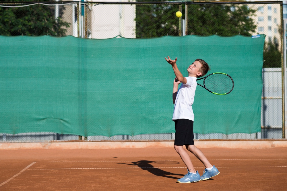 Niño entrenando tenis