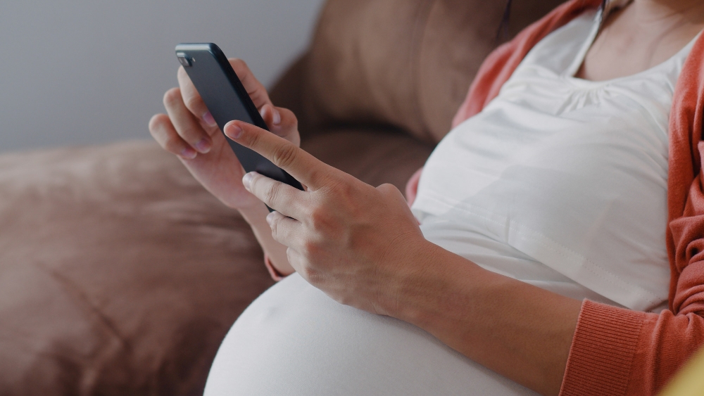 Mujer embarazada busca información en el móvil