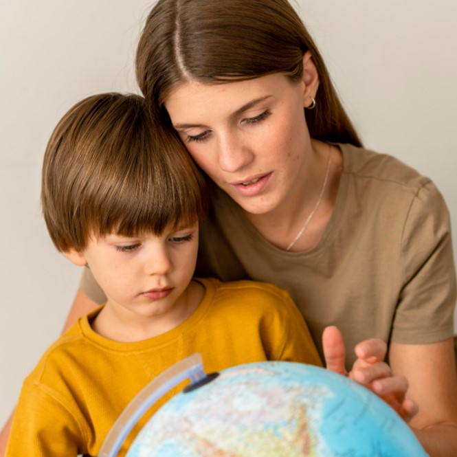 Madre con su hijo mirando un globo del mundo