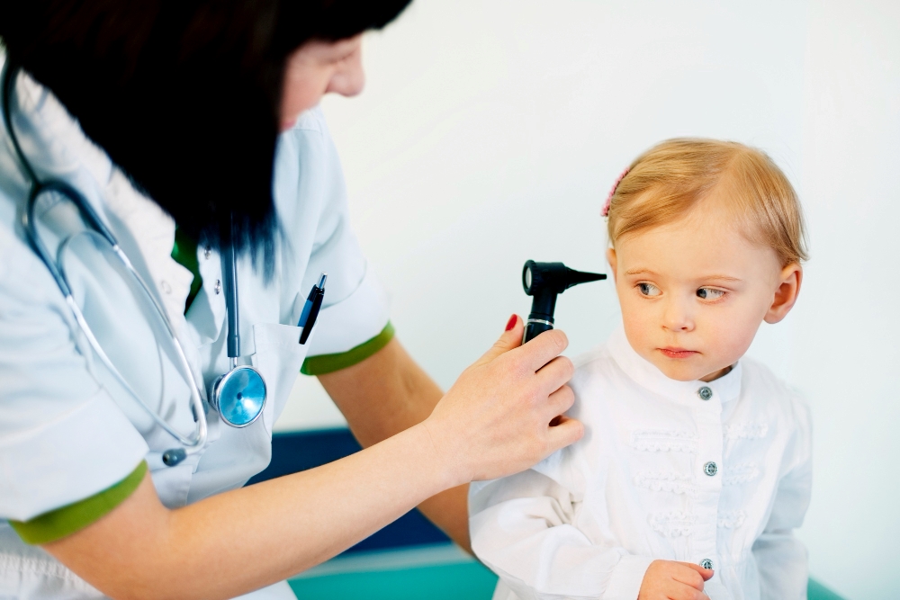 Pediatra haciendo examen de oído a bebé