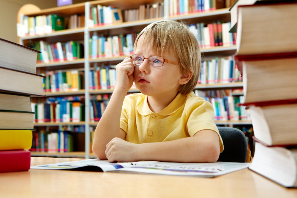 Niño con gafas en la biblioteca