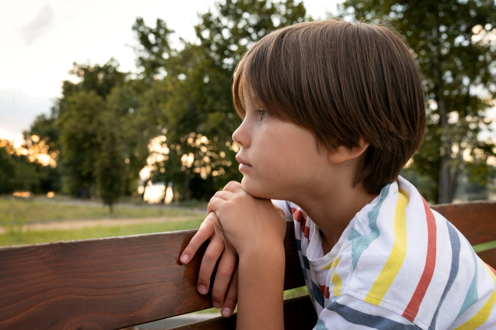 Niño preocupado mira la naturaleza