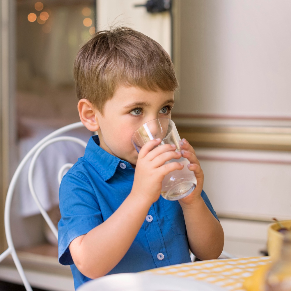Niño con vaso de agua fría
