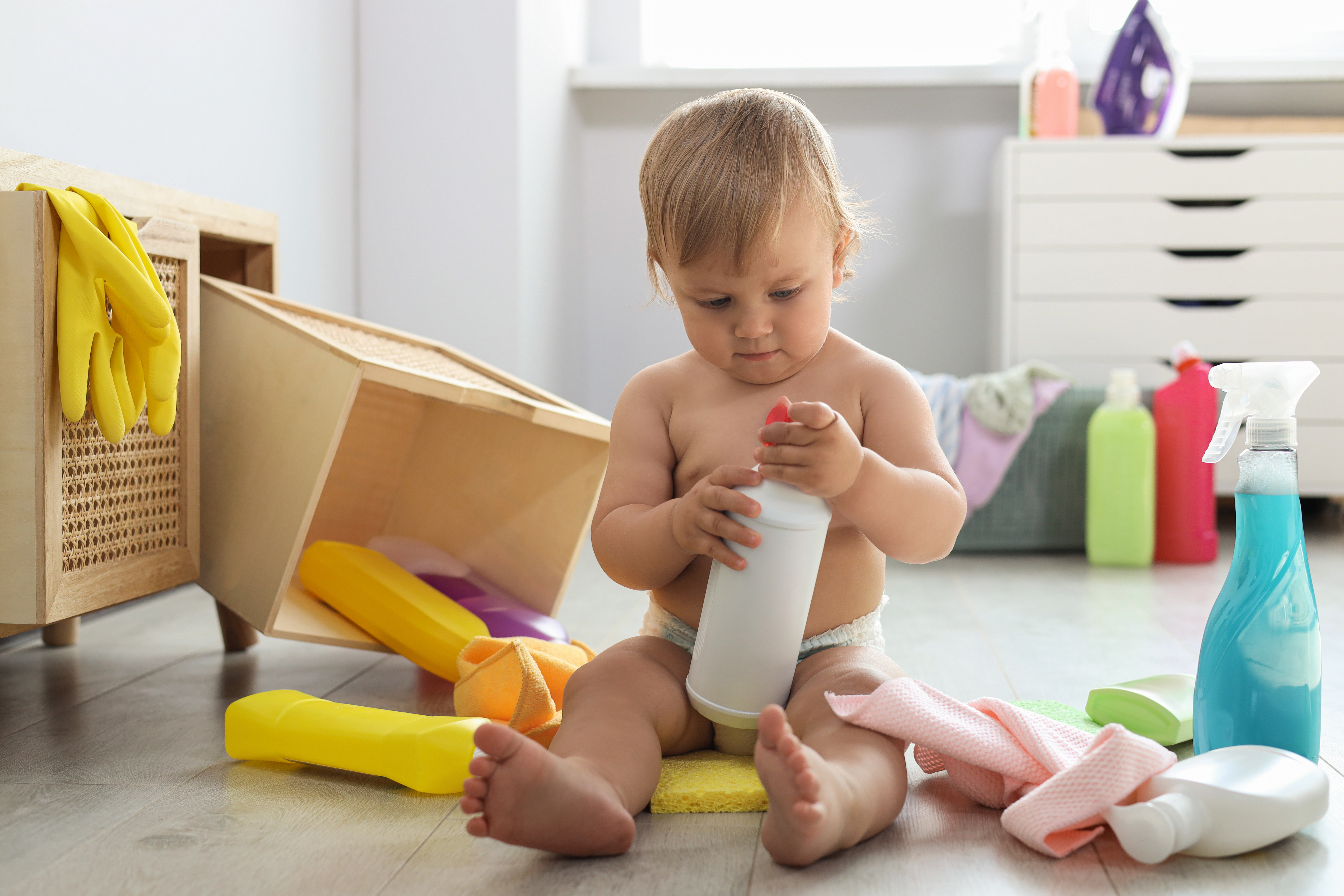 Bebé jugando con productos de limpieza