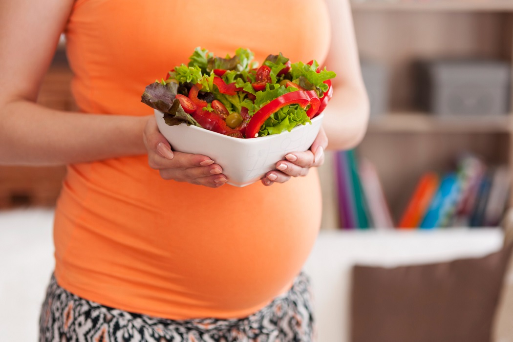 Mujer embarazada con un bol de ensalada