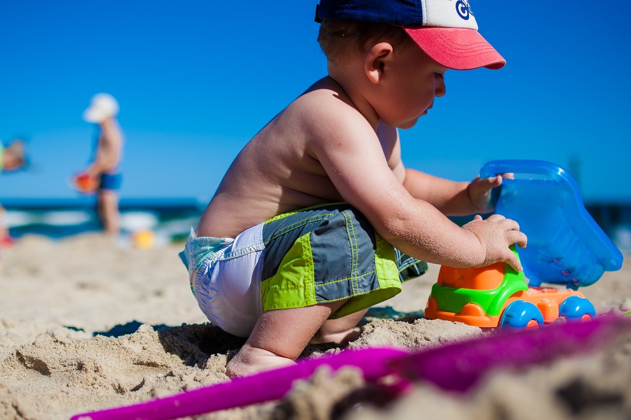 Niño jugando con la arena en la playa