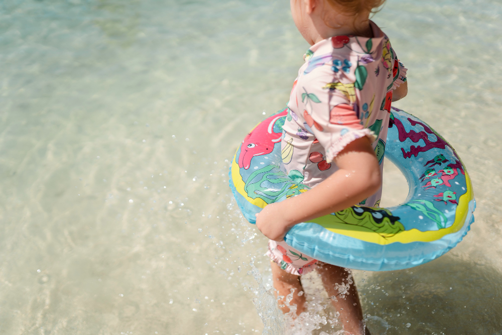 Niño pequeño flotador en la playa