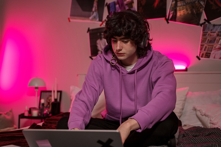 Adolescent a la seva habitació fent ús de l'ordinador - Freepik