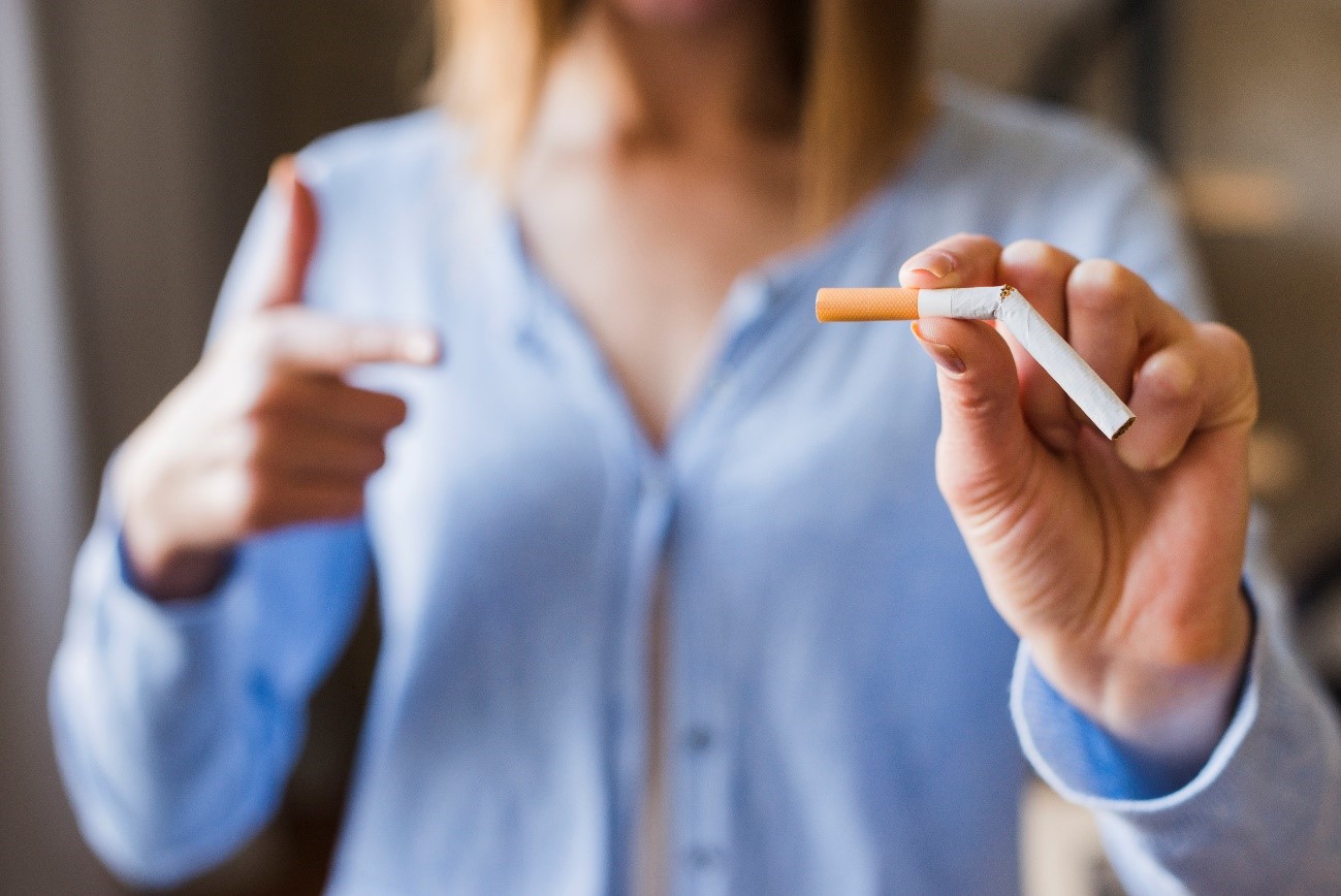 Mujer señalando un cigarrillo partido por la mitad.Freepik