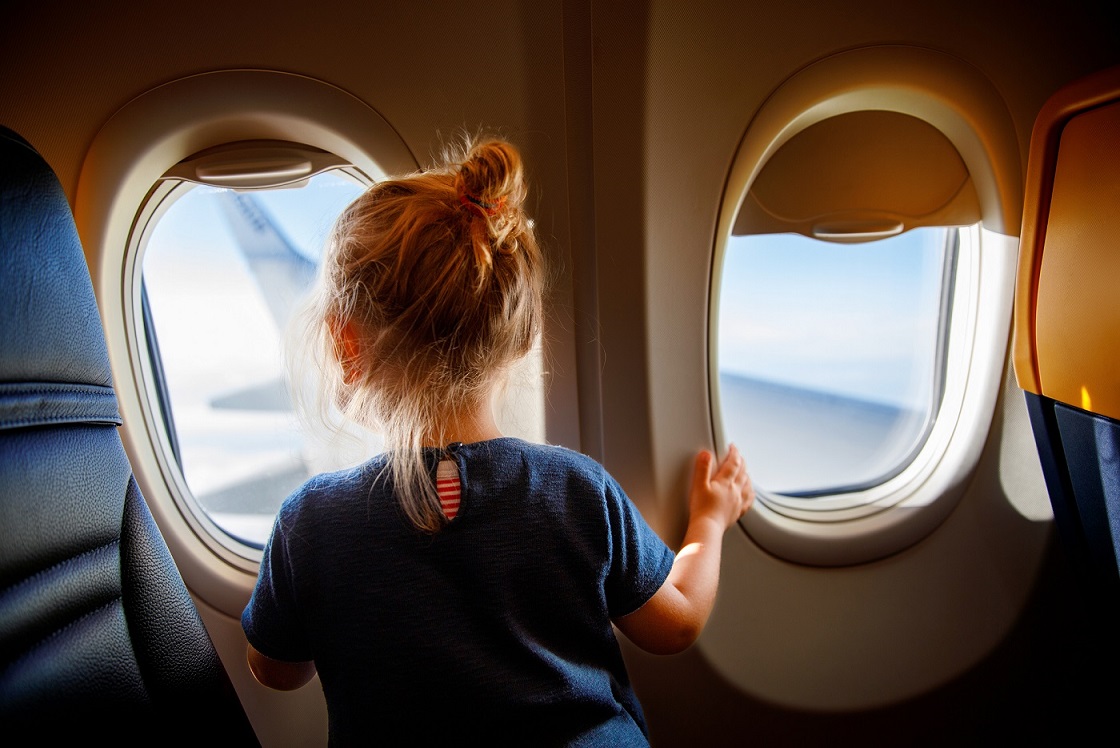 Nena mirant per la finestra de l'avió
