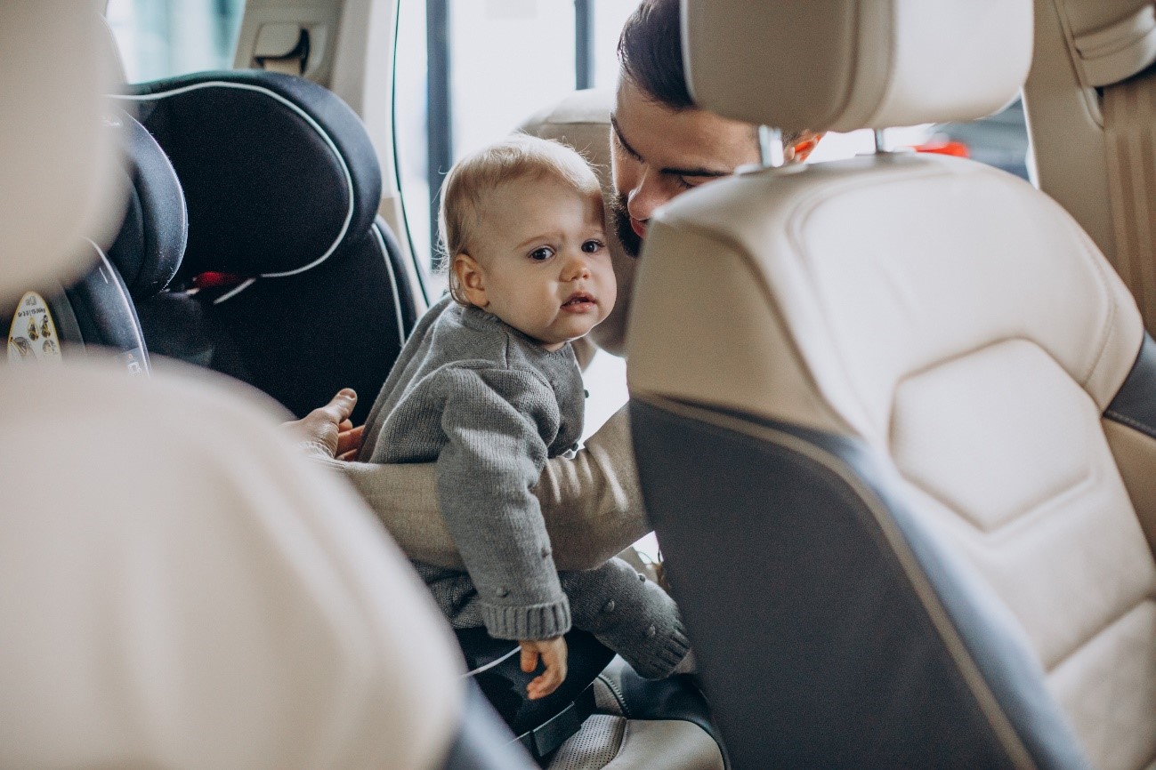 Pare lligant al nadó al cotxe