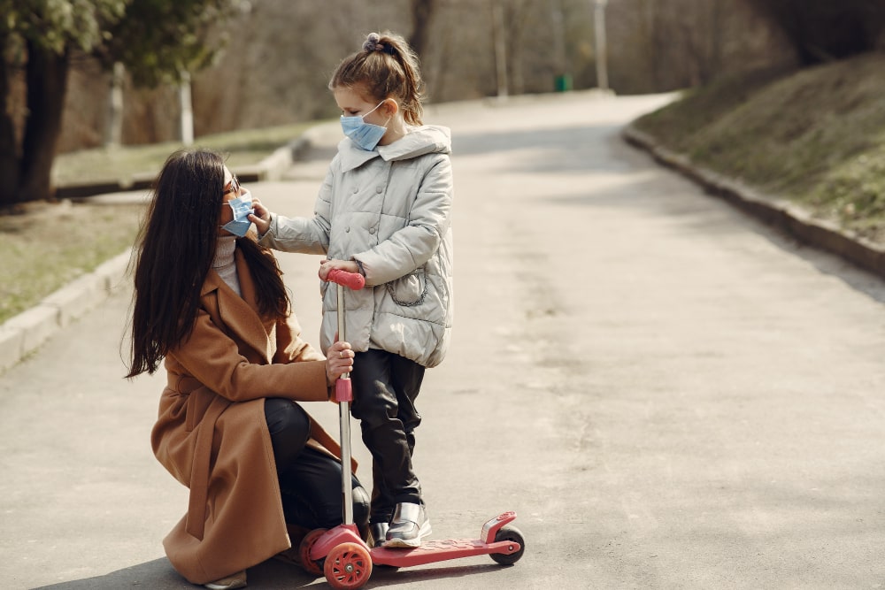 Madre e hija en el parque con mascarilla. Freepik