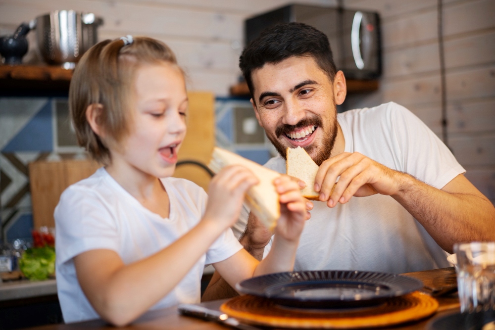 Padre e hijo comen un bocadillo. Imagen de Freepik