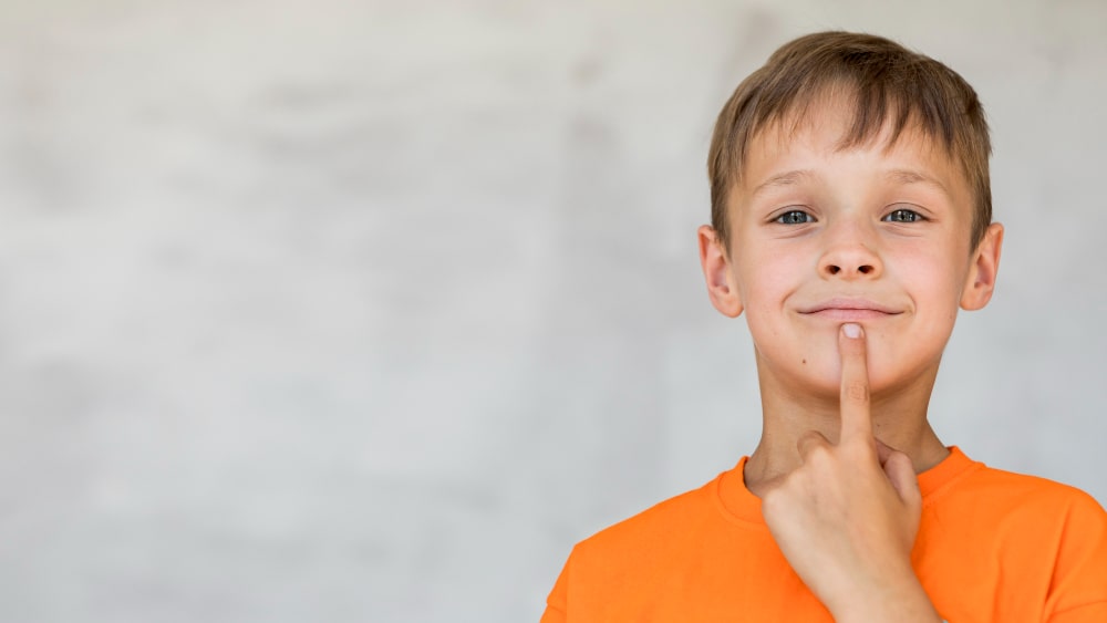 Niño tocándose la boca. Imagen de Freepik