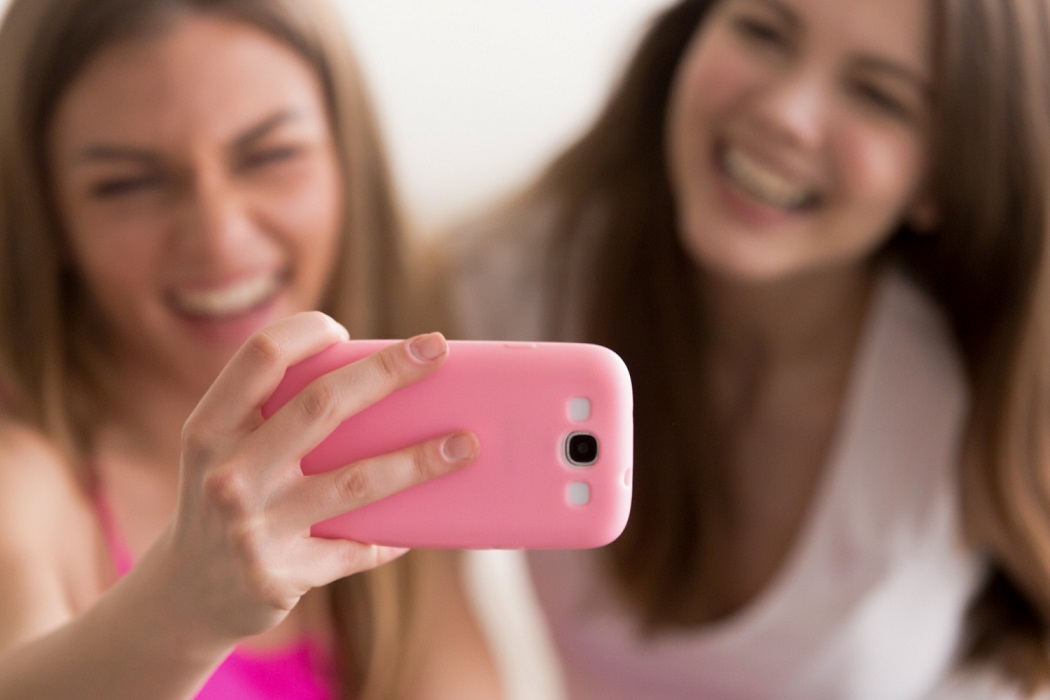 Chicas adolescentes tomándose una selfie con el teléfono móbil - Imagen de freepik