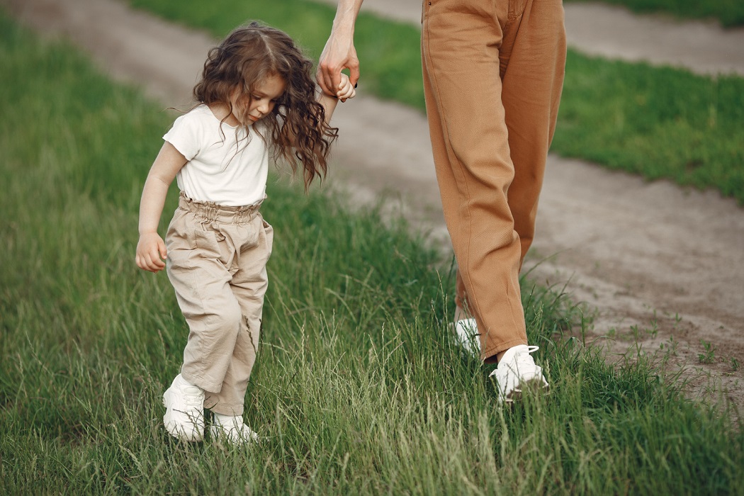 Niña caminando cogida de la mano de su madre - Imagen de prostooleh de freepik