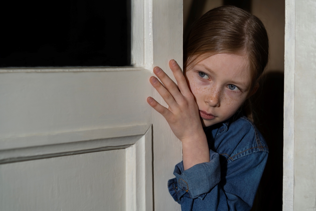 Niña asustada a la puerta