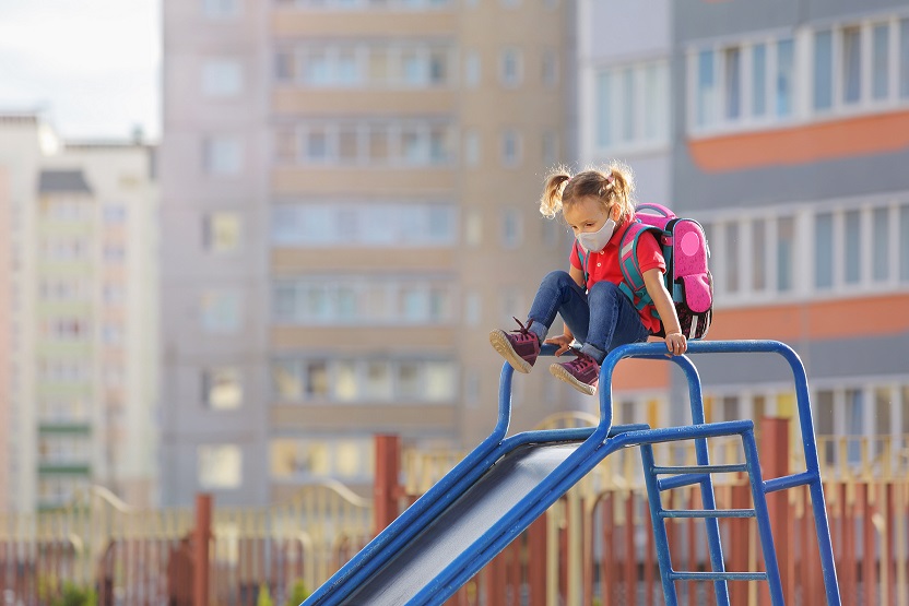 Niña jugando al parque con mascarilla por la contaminación del aire - Fuente de la imagen: Adobe Stock Images