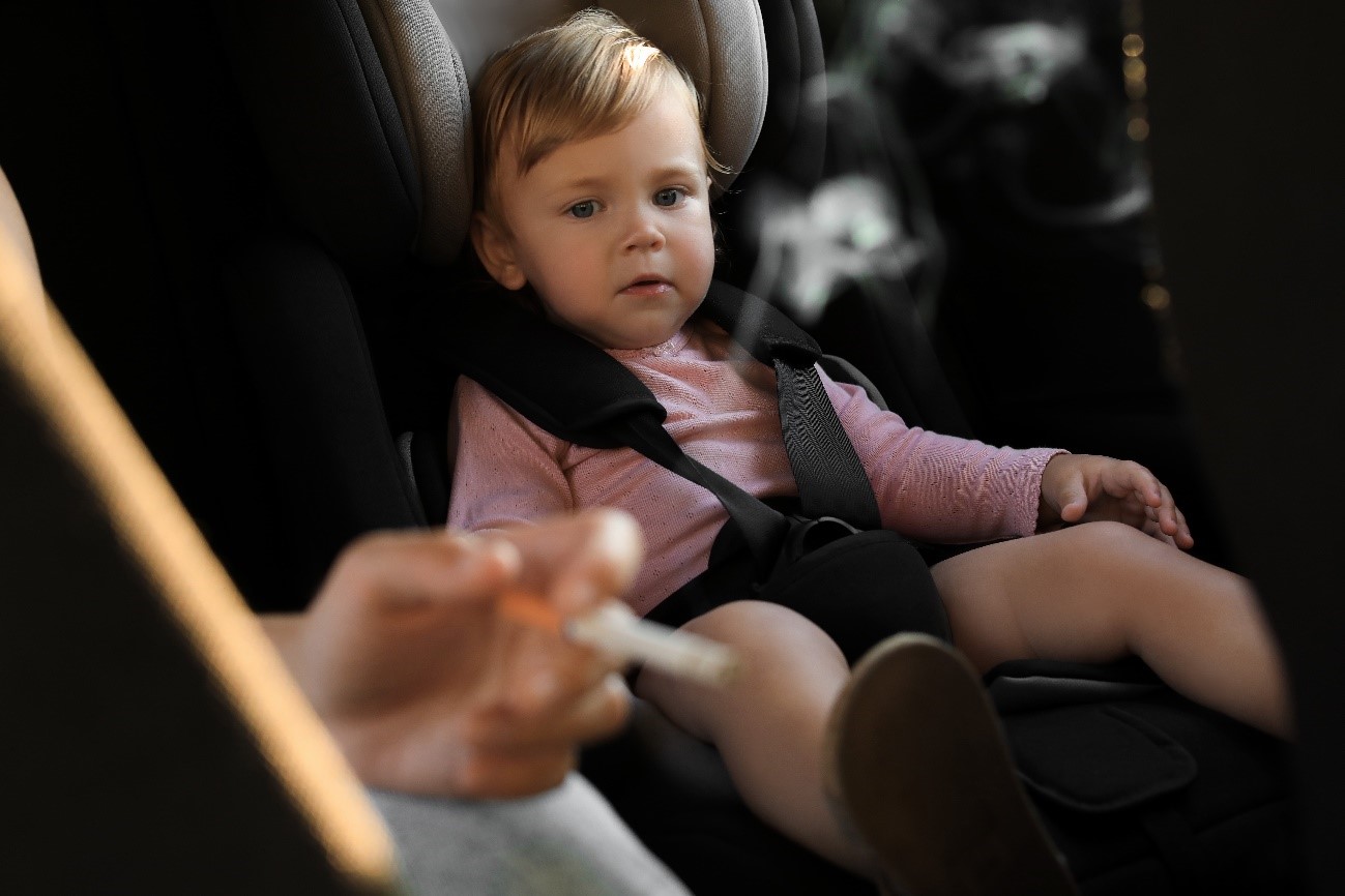 Bebé en el coche y padres fumando