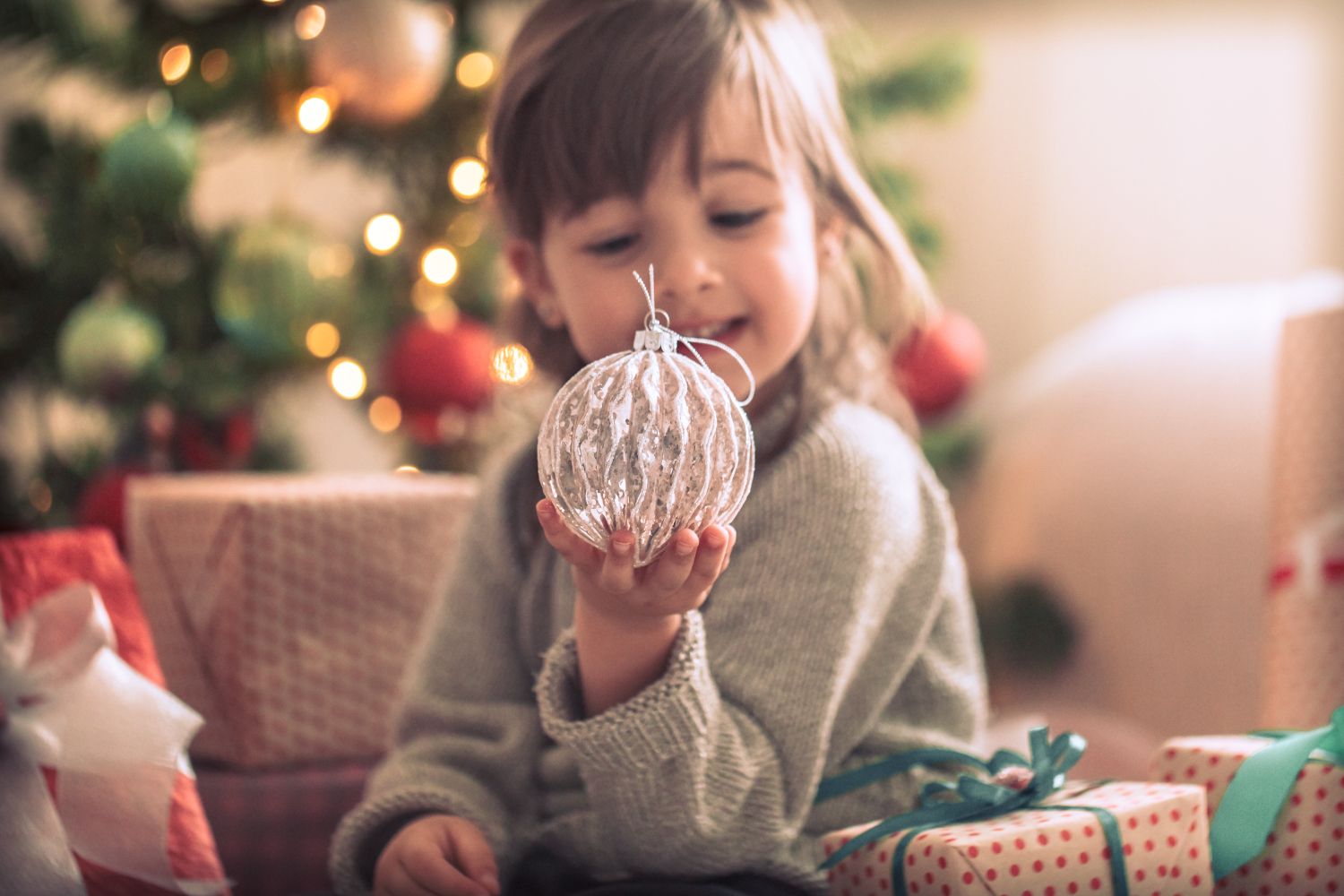 Niña con una bola para el árbol de Navidad - Fuente de la imagen: pvproductions de freepik