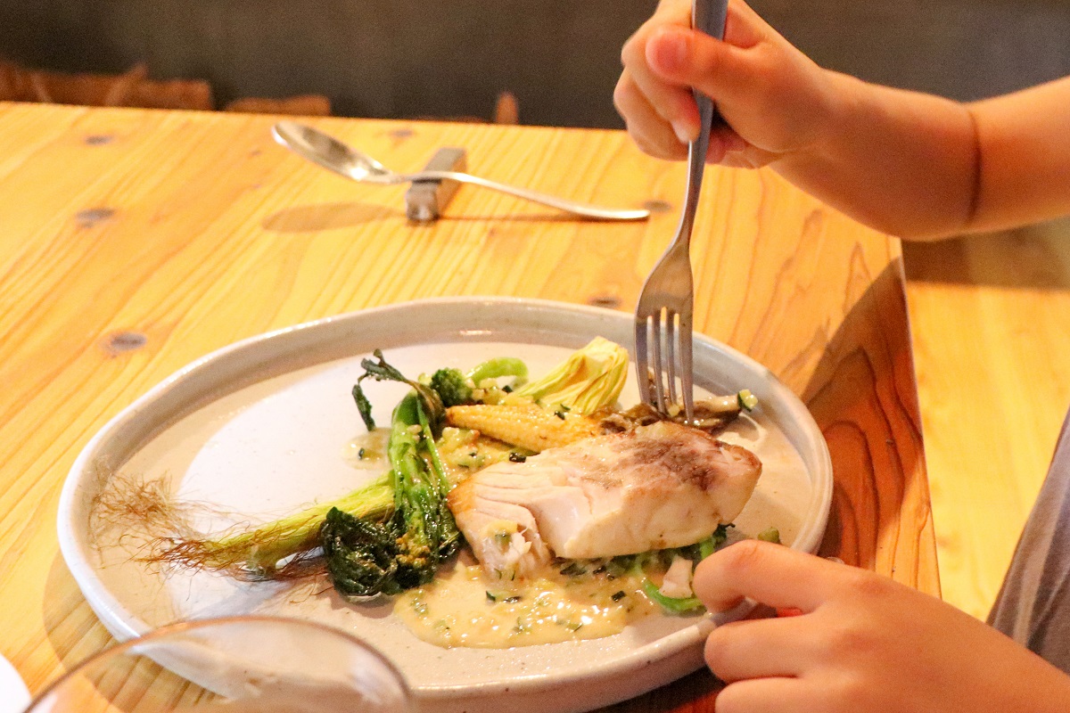 Niño comiendo pescado
